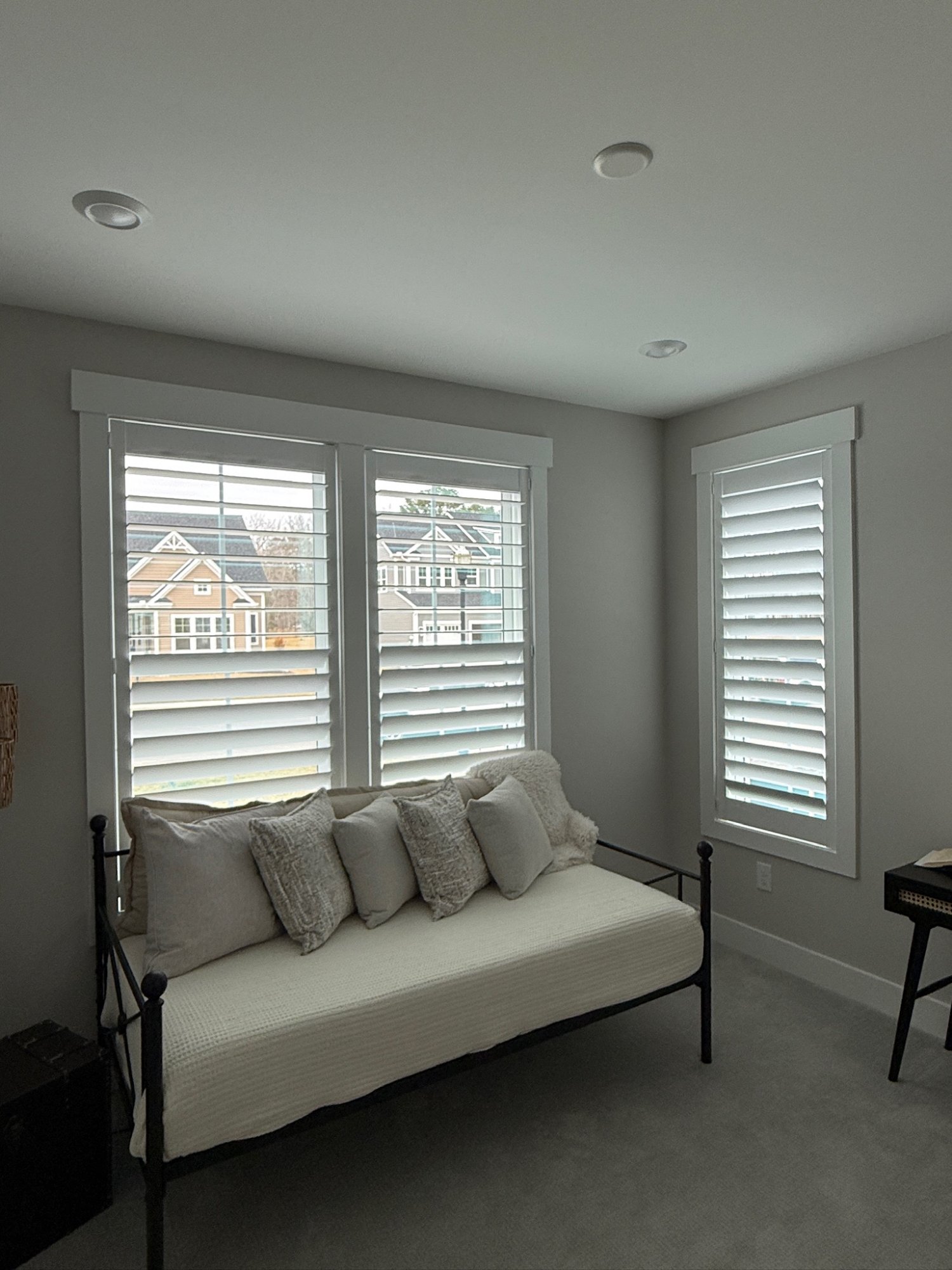 Guest bedroom corner window plantation shutters
